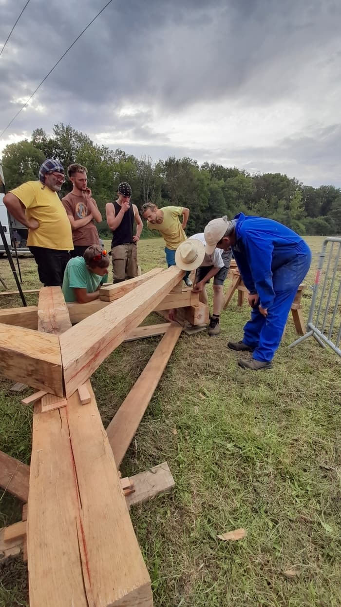 Atelier dessin, taille et assemblage de ferme sur poteaux en troncs de châtaigner équarris à la hache · photo 1
